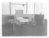 SA0423.5 - Photo of a chair, folding bed, chest of drawers, and desk. Identified on the back.